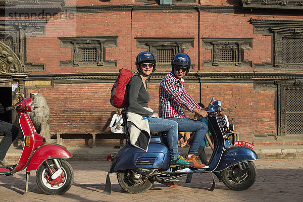 Ein Tourist auf einem Motorroller vor einem Newari-Gebäude in Patan in Kathmandu  Nepal  Asien