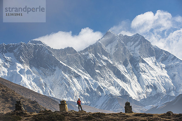 Ein Trekker auf dem Weg zum Everest-Basislager mit dem Everest als entferntem Gipfel links und dem Lhotse als Gipfel rechts  Khumbu-Region  Himalaya  Nepal  Asien