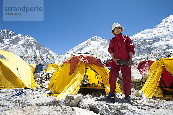 Eine Frau steht kurz nach der Besteigung des Everest neben ihrem Zelt  Khumbu-Region  Himalaya  Nepal  Asien