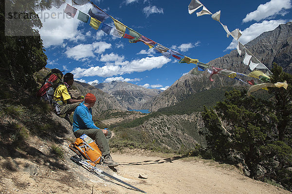 Gebetsfahnen markieren einen hohen Punkt des Weges  an dem die Wanderer mit einem ersten Blick auf den Phoksundo-See belohnt werden  Dolpa-Region  Himalaya  Nepal  Asien