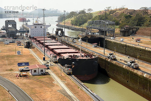 Elektrische Maultiere  die ein Panamax-Schiff durch die Miraflores-Schleusen des Panamakanals führen  Panama  Mittelamerika