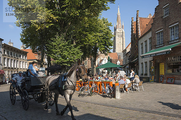Platz mit Café  Pferd und Kutsche  und Turm der Liebfrauenkirche  Brügge  Belgien  Europa