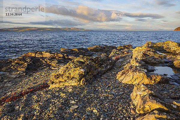 Felsiges Ufer bei Catacol mit Blick über den Kilbrannan Sound auf Mull of Kintyre  Isle of Arran  North Ayrshire  Schottland  Vereinigtes Königreich  Europa
