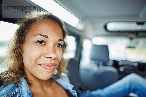 Lächelnde junge Frau im Auto