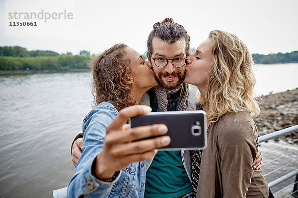 Freunde machen ein Selfie am Flussufer