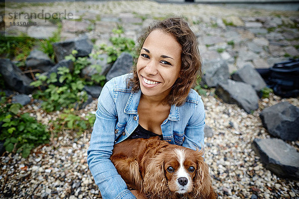 Lächelnde junge Frau mit Hund im Freien