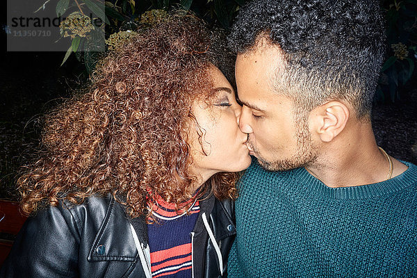 Junges Paar küsst sich im Freien