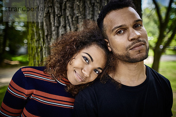 Portrait eines lächelnden jungen Paares im Park