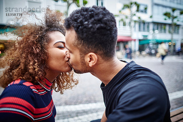 Junges Paar küsst sich in der Stadt