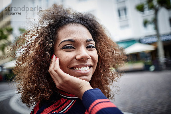 Portrait einer lächelnden jungen Frau in der Stadt