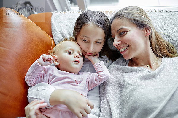 Mutter mit Tochter und Baby entspannt Zuhause
