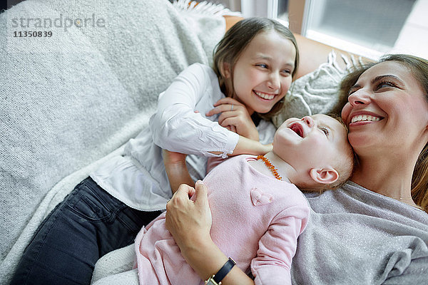 Mutter mit Tochter und Baby entspannt Zuhause