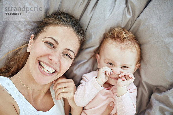 Portrait einer glücklichen Mutter und Baby im Bett