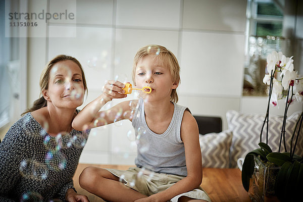 Junge mit Mutter macht Seifenblasen
