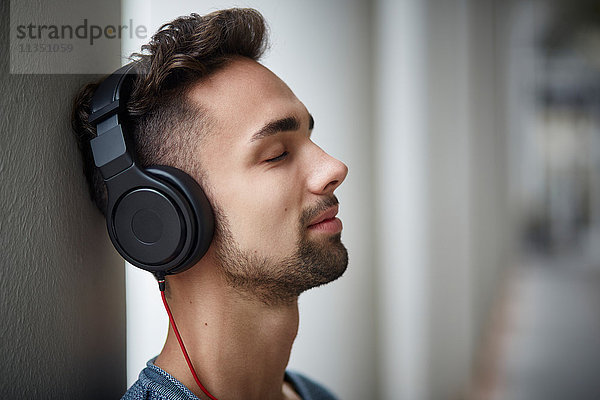 Junger Mann mit Kopfhörern im Freien