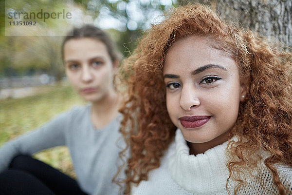 Portrait einer Teenagerin mit Freundin im Park