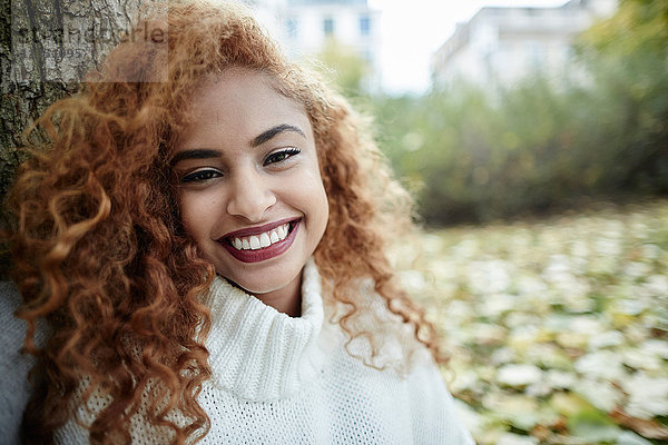 Portrait einer lächelnden Teenagerin im Park