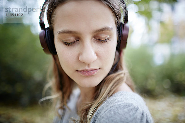 Junge Frau mit geschlossenen Augen und Kopfhörern