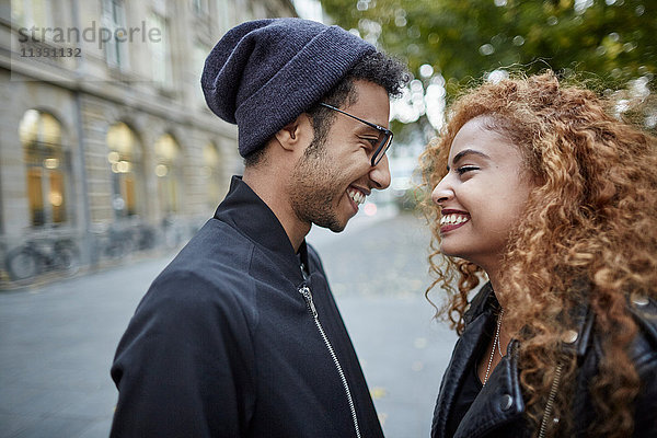Lächelndes junges Paar schaut sich an