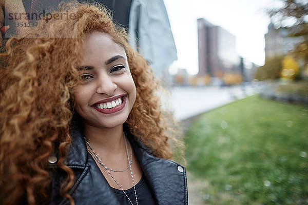 Portrait einer lächelnden Teenagerin in Lederjacke