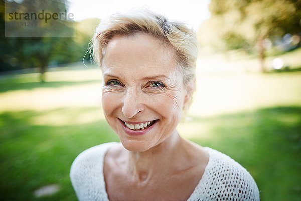 Portrait einer lächelnden reifen Frau im Park