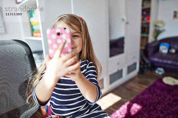 Lächelndes Mädchen hält ein Handy