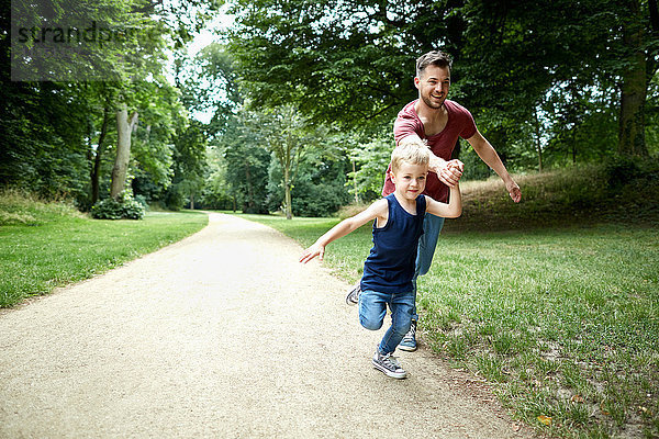 Vater und Sohn rennen im Park