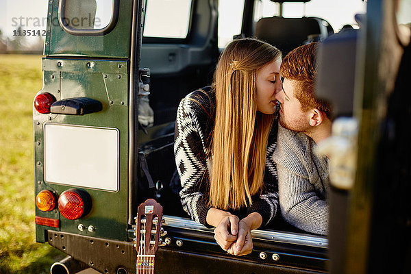 Junges Paar küsst sich in einem Auto