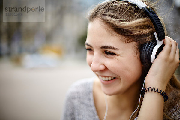 Lächelnde junge Frau mit Kopfhörern