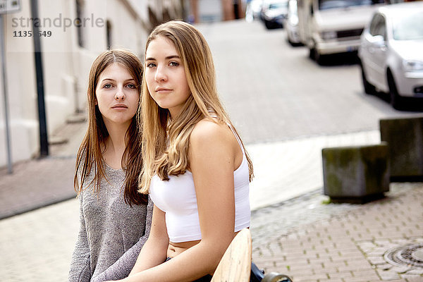 Portrait von zwei jungen Frauen mit Skateboard