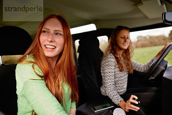Zwei glückliche junge Frauen auf einer Autoreise