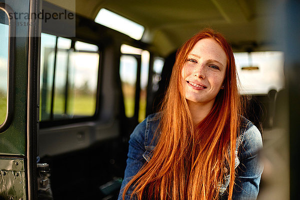 Portrait einer lächelnden jungen Frau im Auto