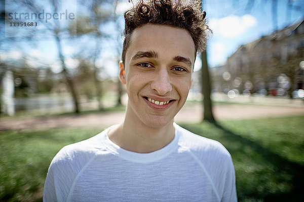 Portrait eines lächelnden Teenagers in einem Park