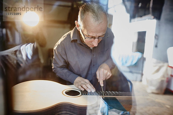 Gitarrenbauer arbeitet in seiner Werkstatt