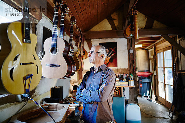 Nachdenklicher Gitarrenbauer in seiner Werkstatt