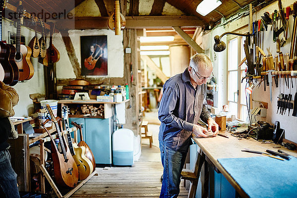 Gitarrenbauer arbeitet in seiner Werkstatt
