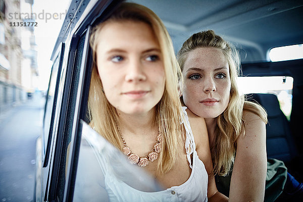 Zwei junge Frauen im Auto schauen aus dem Fenster