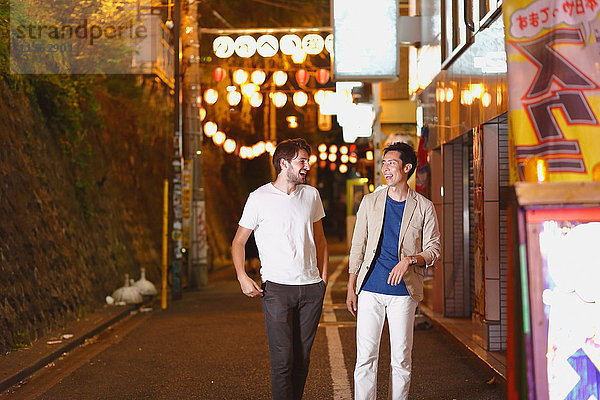 Kaukasischer Mann genießt das Nachtleben in Tokio mit japanischem Freund  Japan