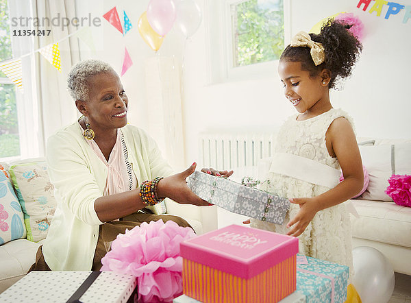Mädchen schenkt Großmutter Geburtstagsgeschenk auf der Party