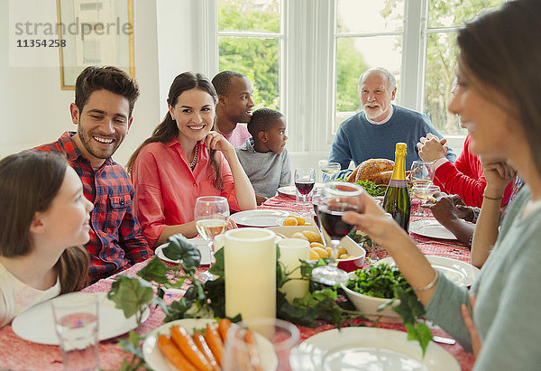 Multi-ethnische Mehrgenerationen-Familie genießt Weihnachtsessen am Tisch