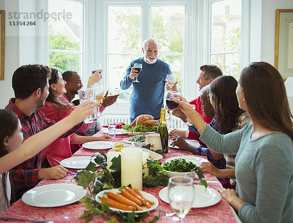 Großvater macht Toast mit Wein am Weihnachtstisch