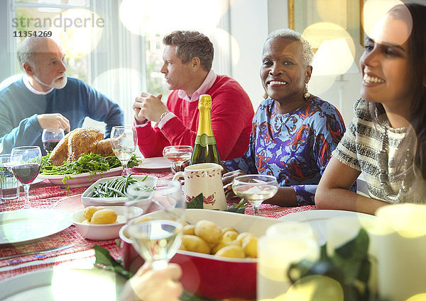 Portrait lächelnde Seniorin beim Weihnachtsessen mit der Familie am Tisch