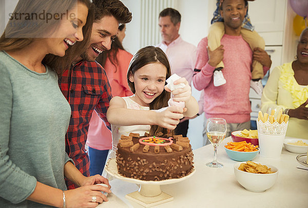 Lächelndes Familienglasurschokoladenkuchen in der Küche