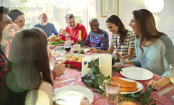 Lachende multiethnische Familie genießt Weihnachtsessen bei Tisch