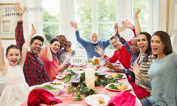 Portrait begeisterte multiethnische Mehrgenerationen-Familie winkt am Weihnachtstisch