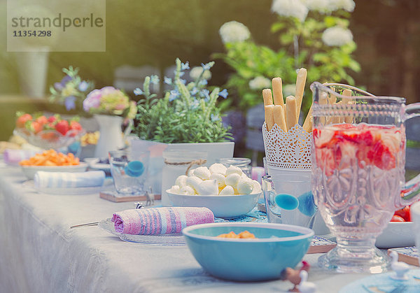 Erdbeerwasser und Desserts auf der Gartenparty-Terrasse