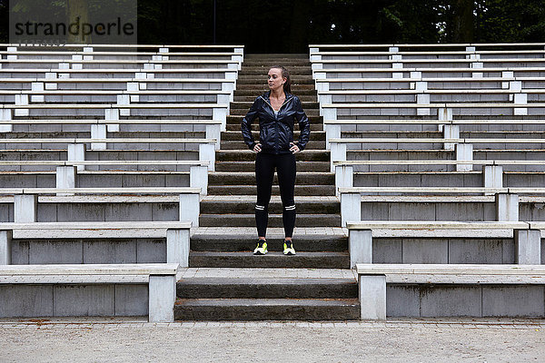 Junge Frau trainiert  bereitet sich auf das Laufen auf der Stadiontreppe vor