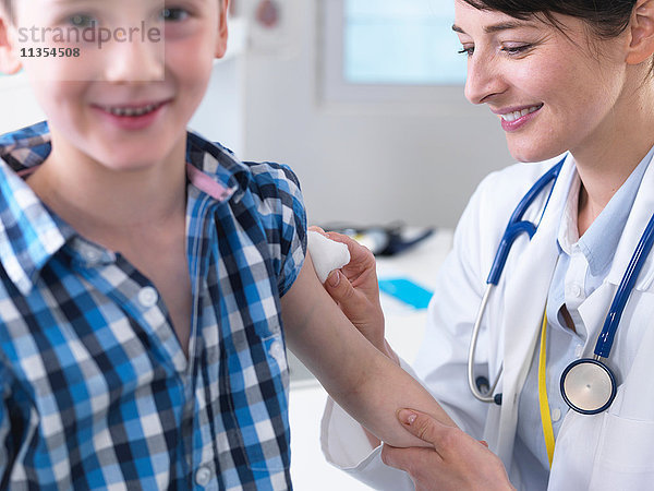 Arzt beruhigt Jungen nach Impfung in Klinik