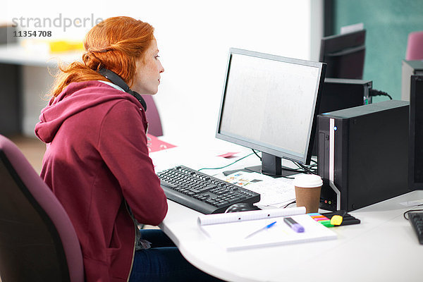 Junge Studentin am Schreibtisch-Lesecomputer