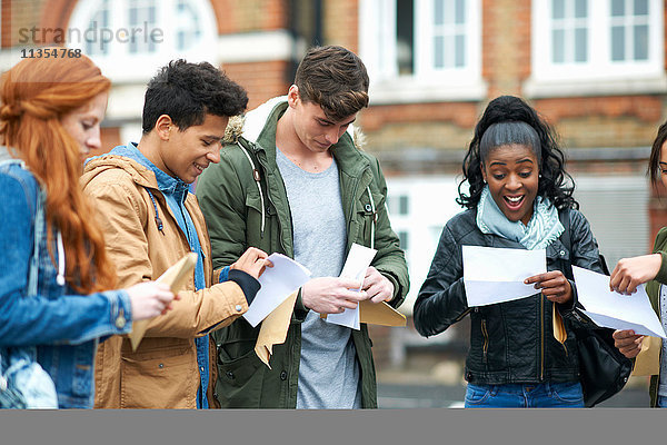 Junge erwachsene College-Studenten lesen Prüfungsergebnisse auf dem Campus